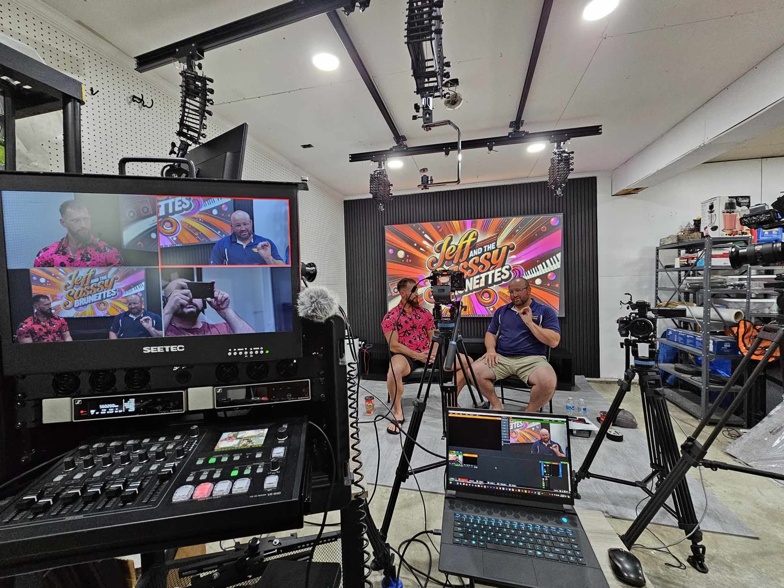 Two performers on a green screen set at The Studio Creative, with a live switcher and multiview monitor in the foreground