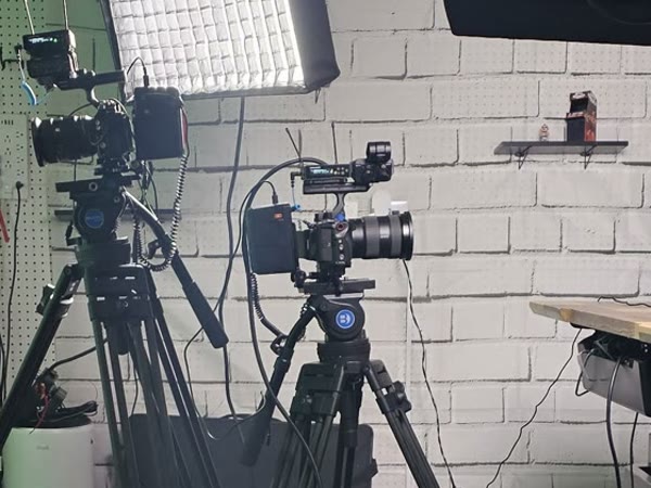 Two Sony cameras on fluid-head tripods beside an Aputure soft light in The Studio Creative's studio