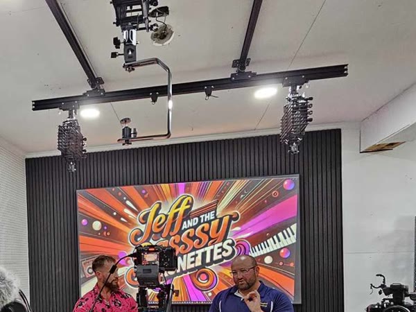 An overhead lighting rail above the curved LED video wall in The Studio Creative's studio