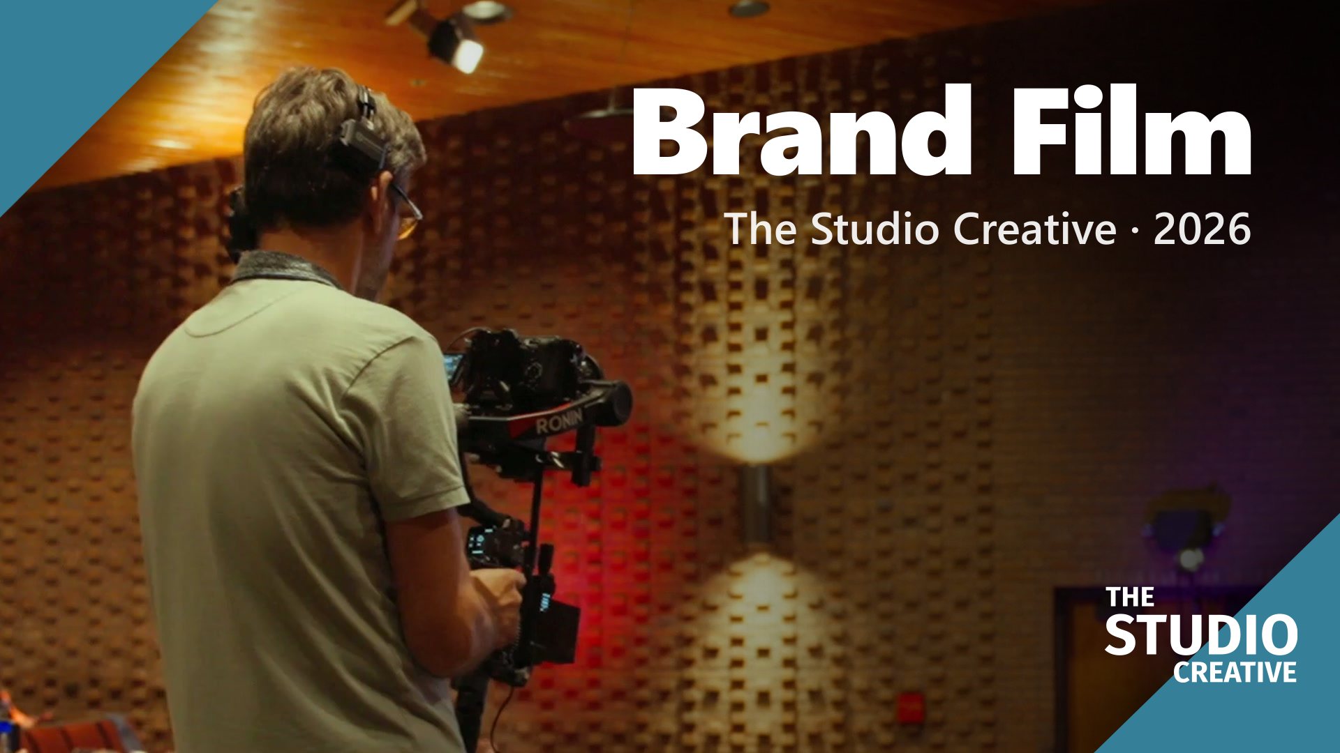A crew member with a camera on set, the opening frame of The Studio Creative brand film